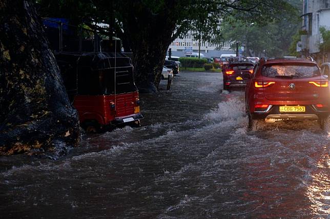 Cars run on a waterlogged road in Colombo, Sri Lanka, Nov. 26, 2024. (Photo by Gayan Sameera/Xinhua)