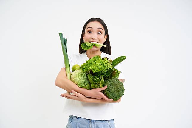 portrait-asian-woman-munching-lettuce-holding-green-organic-vegetables-diet-white-background
