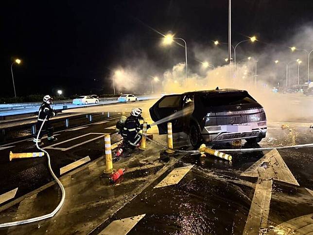 國道1號楊梅休息站今晚發生一輛電動車自撞起火燃燒事件，車上共8人受困，救護人員於7點35分趕赴現場發現男駕駛已明顯死亡，其餘7人送醫搶救中。(桃園市消防局提供)