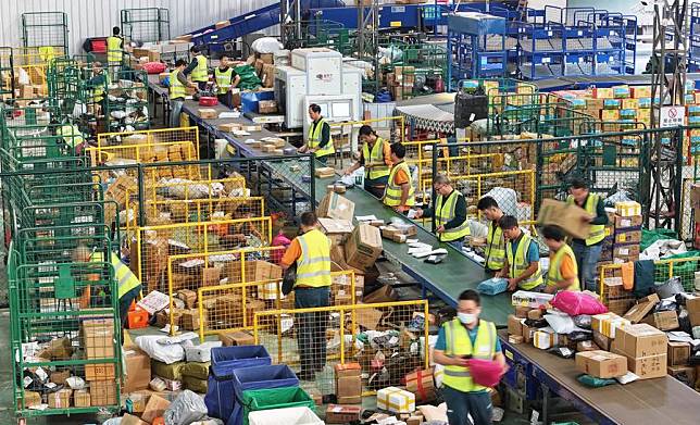 A drone photo shows staff members sorting packages at a logistic center of Daoxian branch of China Post in Daoxian County, central China's Hunan Province, Nov. 11, 2024. (Photo by He Hongfu/Xinhua)