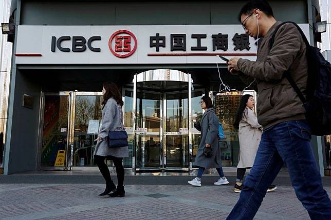 People walk past a branch of the Industrial and Commercial Bank of China in Beijing on April 1, 2019. Photo: Reuters