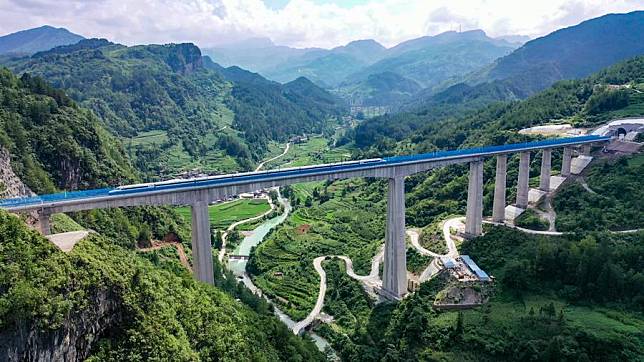 A test train passes a grand bridge in Guiding County, southwest China's Guizhou Province, June 26, 2023. (Photo by Long Jianrui/Xinhua)