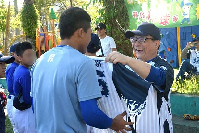 芥菜種會執行長李肇家為孩子們披上繡有名子的專屬球衣，鼓勵孩子勇敢朝夢想邁進。(芥菜種會提供)