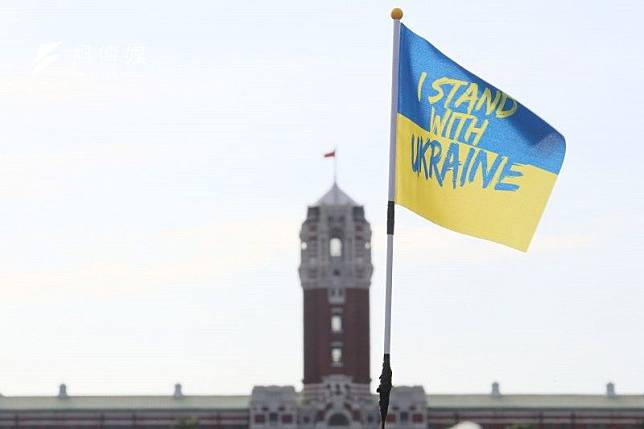 2022年3月13日，台灣民間團體舉辦「台灣支持烏克蘭」遊行活動。圖為寫著「與烏克蘭同陣線」的烏克蘭旗幟，背景則是我國總統府建築（柯承惠攝）