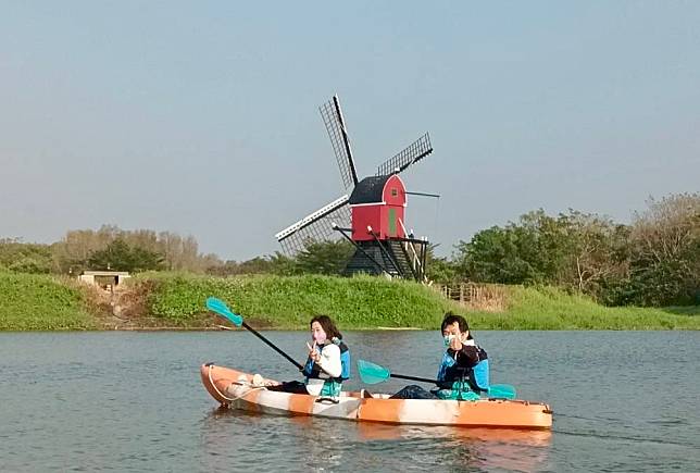 在德元埤水域划獨木舟，可從水面與園區最具指標性的荷蘭風車合影。（觀光旅遊局提供）