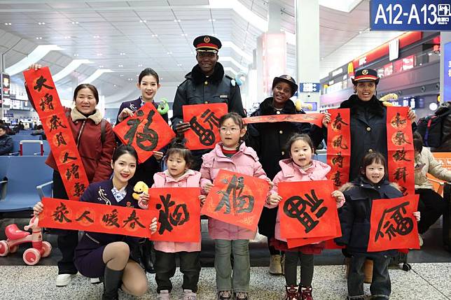 Foreign student volunteers pose for photos with railway workers and passengers at Lanzhou West Railway Station in Lanzhou, northwest China's Gansu Province, Jan. 18, 2025. (Xinhua/Chen Bin)