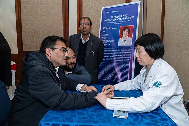 A doctor from the Affiliated Traditional Chinese Medicine Hospital of Southwest Medical University makes a free diagnosis during a traditional Chinese medicine (TCM) overseas tour in Kathmandu, Nepal, on Dec. 3, 2024. (Photo by Hari Maharjan/Xinhua)