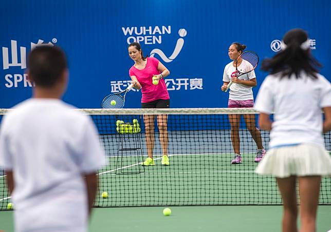 Li Na (2nd, L) teaches tennis during the 2015 WTA Wuhan Open on September 29, 2015. (Xinhua/Xiao Yijiu)