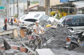 馬太鞍溪堰塞湖溢流重創光復市區，26日一位居民騎車經過滿目瘡痍的街道。（圖／中國時報范揚光攝）