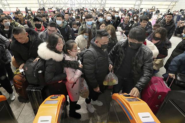 Travellers wear face masks as they line up at turnstiles at a railway station in Nantong, eastern China's Jiangsu province, on Wednesday. Photo: AP