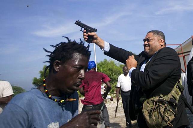 海地參議員費提耶23日遭抗議群眾包圍，竟突然開槍，傷及美聯社記者與警衛。（AP）