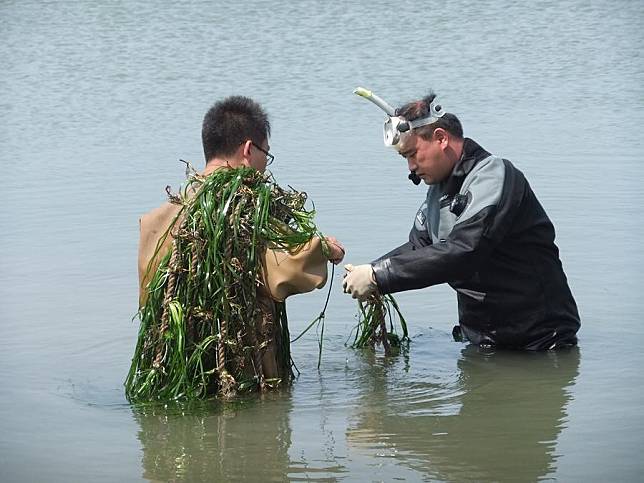 This file photo taken on Aug. 25, 2011 shows Zhang Peidong &reg;, a professor at the Ocean University of China, guiding his student to do experiments in Laizhou, east China's Shandong Province. (Xinhua)