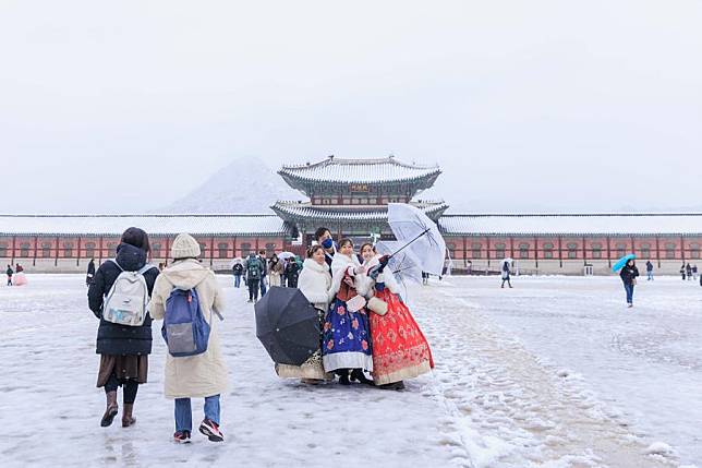 This photo taken on Nov. 27, 2024 shows people posing for photos in snow in Seoul, South Korea. (Photo by Park Jintaek/Xinhua)