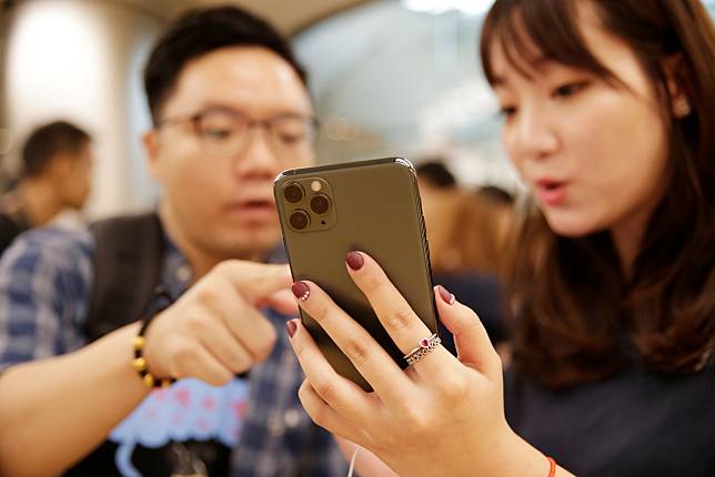 A customer touches Apple's new iPhone 11 Pro Max after it went on sale at the Apple Store in Beijing