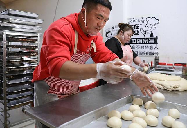 Wei Zhongshuai and his wife make biscuits at his bakery in Xiongyue Town, Bayuquan District of Yingkou City in northeast China's Liaoning Province, April 24, 2024.(Xinhua/Yao Jianfeng)