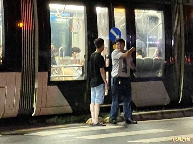 高雄輕軌深夜再傳車禍疑遭轎車擦撞，司機長(右)下車與駕駛(右)釐清「撞」況。(記者黃良傑攝)