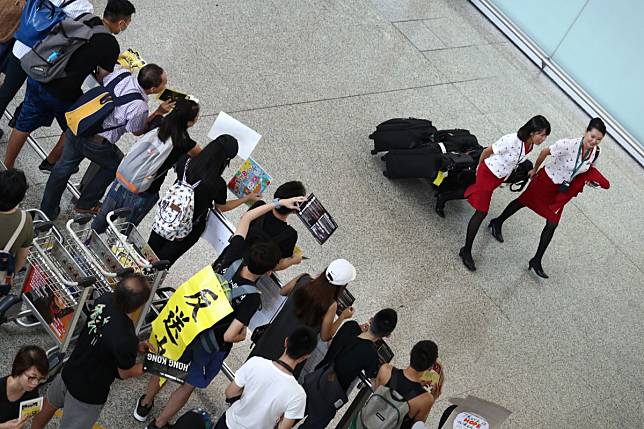 Cathay Pacific cabin crew walk past anti-government protesters at the Hong Kong International Airport on August 11. Vetting flight crew over their political beliefs echoes the choices that led to disaster in 1950s and 1960s China, and the lost decades under Mao Zedong. Photo: Nora Tam