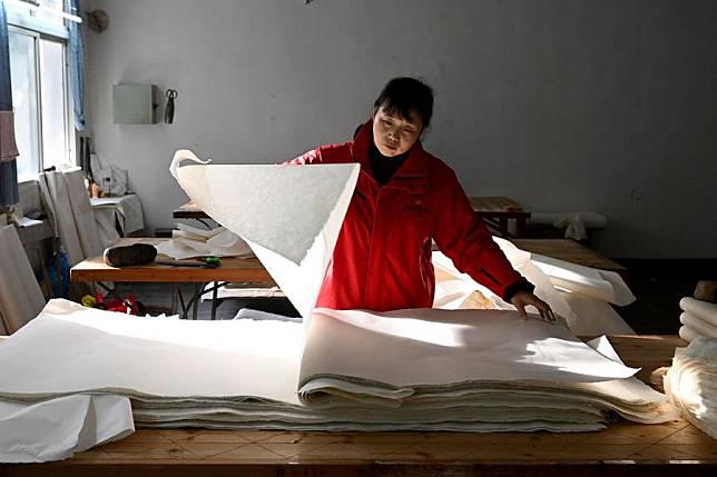 A worker is seen at the workshop of China Xuan Paper Co., Ltd. in Jingxian County, east China's Anhui Province, Dec. 7, 2023. (Xinhua/Huang Bohan)