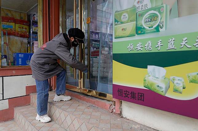 A shop owner opens the door in Jishishan County, northwest China's Gansu Province, Dec. 23, 2023. (Xinhua/Fang Xin)