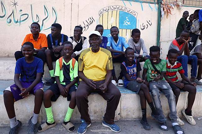 Kamal Mahmoud &copy;, a Sudanese working as a football coach, sits with refugee boys during a football game at a sports academy in Cairo, Egypt, on June 18, 2024. (Xinhua/Ahmed Gomaa)