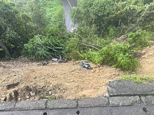 新北市新店區涵煙翠社區前路段18日下午因大雨導致 土石崩落坍方，多輛機車也隨土石滑落毀損。警方已 先封閉該處路段，相關單位緊急派員搶修中。 中央社