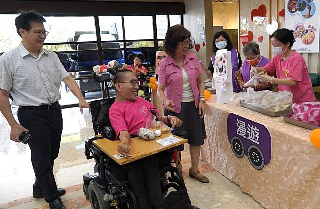 新北市立八里愛心教養院昨日卅九週年院慶活動中，市府社會局副局長許秀能（左三）與教養院長謝鑫敏（左）帶院生逛園遊會。（記者吳瀛洲攝）