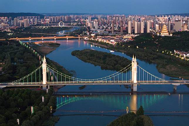 An aerial drone photo taken on May 9, 2024 shows a night view along the Weihe River in Baoji, northwest China's Shaanxi Province. Located at the foot of the Qinling Mountains and along the Weihe River, Baoji of northwest China's Shaanxi Province has continued to make efforts to create a livable urban environment. In recent years, a total of 36 small city parks have been built, providing citizens with activity space for leisure and sports, and improving the ecological environment of the city as well. (Xinhua/Shao Rui)