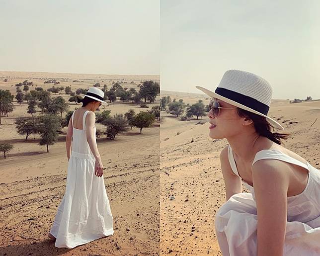 Niki身穿白色吊帶長裙，於一望無際的沙漠漫步。周勵淇ig