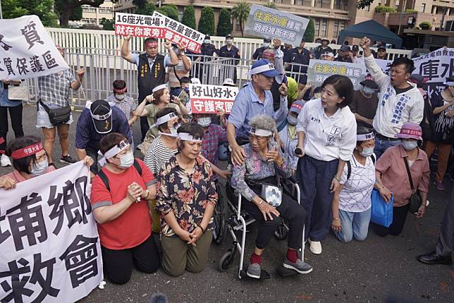 嘉義縣大埔鄉部分土地將設光電場，引起當地區民不滿，國民黨立委王育敏（前右三）十七日率近百名當地鄉親到行政院大門口抗議，居民下跪陳情。（中央社）