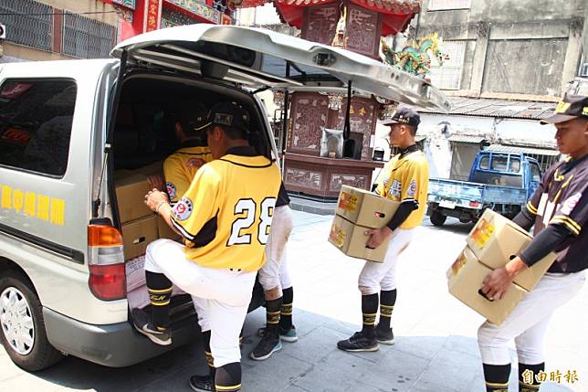東石高中棒球隊成員扛著物資上車。(記者林宜樟攝)