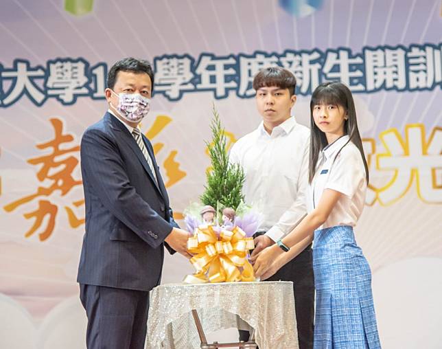 嘉藥迎新傳統贈樹儀式，由兩位新生代表從校長李孫榮（左一）手中接下樹苗。（記者黃文記攝）