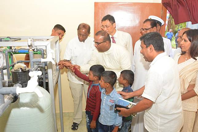 A boy switches on water purification facility in Moragollagama village of Kurunegala, Sri Lanka, Aug. 14, 2019. (Photo by Thushara/Xinhua)