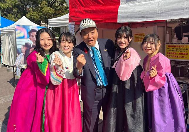 日本名古屋市長河村隆之，他在和女偶像合照時竟然擺出象徵女性生殖器的手勢。(圖擷自推特@takigare3)