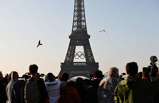 People watch the Olympic rings on the Eiffel Tower, in Paris, France, on June 7, 2024. The Olympics rings are unveiled on the Eiffel Tower early in the morning of Friday as the French capital marks 50 days until the start of the upcoming Paris 2024 Olympic Games. (Xinhua/Gao Jing)