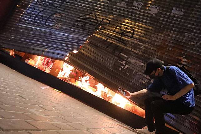 A shop in Wan Chai is set on fire by anti-government protesters. Market observers say buying sentiment for retail shops has further weakened because of vandalism and arson. Photo: Felix Wong