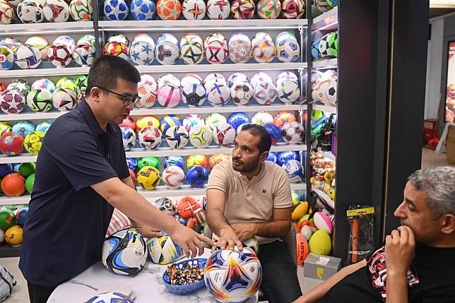 A businessman introduces football products to customers from Egypt in Yiwu, east China's Zhejiang Province, May 30, 2024. (Xinhua/Huang Zongzhi)