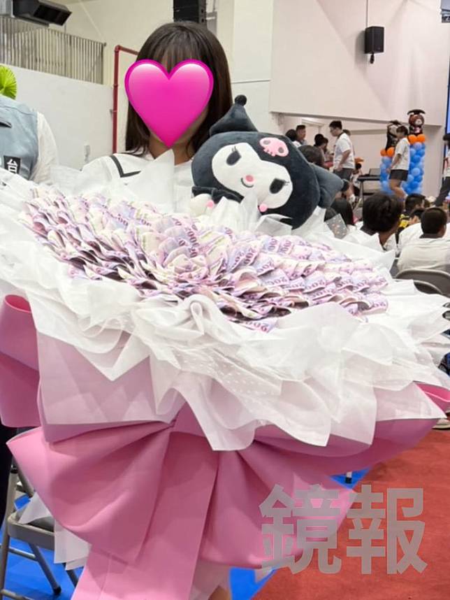 廖姓女國中生捧著17.6萬元的現金花束，成為畢業典禮會場的焦點人物。畫面授權threads lfouiku_1201