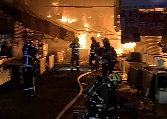 台中市東興市場暗夜發生大火，火勢相當猛烈，消防人員獲報趕到現場冒險進入市場救火。（記者陳金龍翻攝）