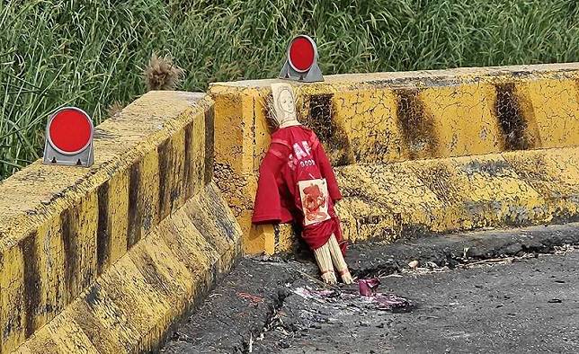 嘉義縣大林鎮三疊溪旁，一尊紅衣草人被放置在路邊。(記者林宜樟翻攝)