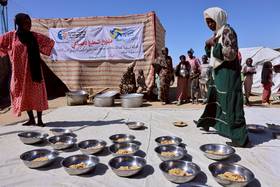 2025年11月22日，查德東部的臨時難民營，逃離蘇丹法舍的難民婦女，為也從當地逃出的孤兒準備餐點。路透社