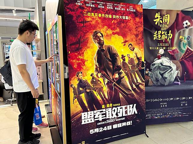 This photo taken with a mobile phone shows a man taking his ticket from a ticket vending machine at a cinema in Beijing, capital of China, June 7, 2024. (Xinhua/Shen Anni)