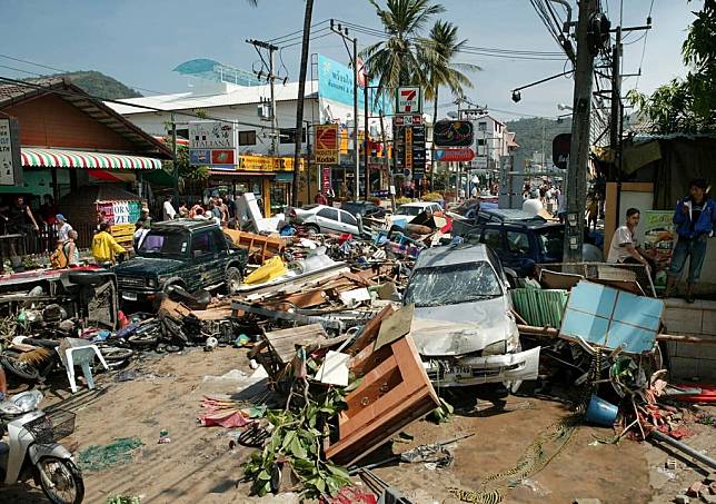 ถนนสายหนึ่งเต็มไปด้วยยานพาหนะที่เสียหายและเศษซากปรักหักพัง หลังจากพื้นที่ถูกคลื่นยักษ์ซัดกระหน่ำที่หาดป่าตอง จังหวัดภูเก็ต ประเทศไทย วันอาทิตย์ที่ 26 ธันวาคม 2547 (ภาพถ่ายโดย AP Photo/Karim Khamzin)