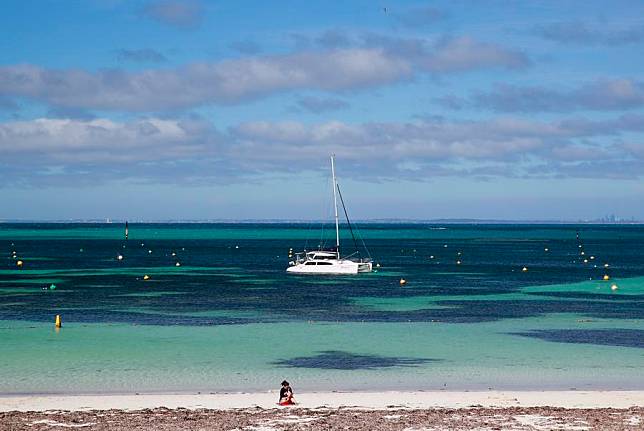 A tourist reads a book on the beach on Rottnest Island in Australia, Oct. 25, 2024.