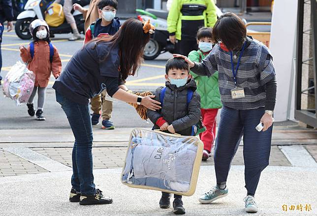 台北市高中(含)以下各級學校11日開學，景美國小一名學童提著棉被等大包小包物品重回校園，師長也上前迎接。(記者廖振輝攝)