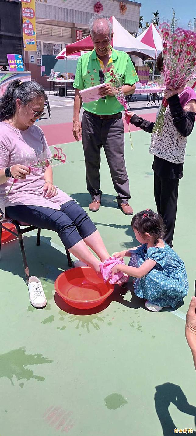 4歲小女孩曾宜芹，為媽媽張蓉渝洗腳，動作熟練。(記者陳鳳麗攝)