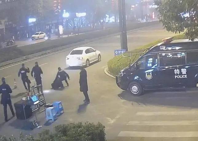 李某駕駛的白色私家車衝越警方路障。