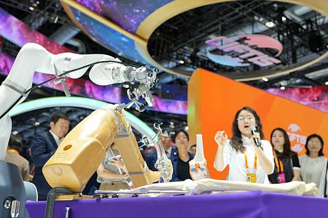 Visitors watch an AI-powered orthopedic surgical robot during the 2024 China International Fair for Trade in Services (CIFTIS) at the China National Convention Center in Beijing, capital of China, Sept. 13, 2024. (Xinhua/Ju Huanzong)