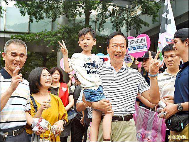 鴻海董事長郭台銘昨前往台北市信義區香堤大道廣場，發送果凍財神包，並與熱情的民眾合照。(記者方賓照攝)
