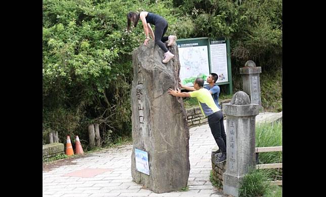 女子攀爬玉山登山口巨石碑在網路引發熱議。（翻攝臉書社團登山通報站）