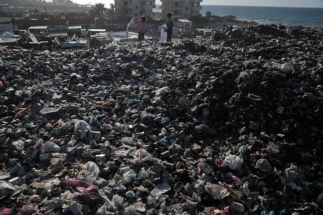 Palestinian children collect items at a garbage dump in the al-Nuseirat refugee camp in central Gaza Strip, on Dec. 24, 2024. (Photo by Rizek Abdeljawad/Xinhua)